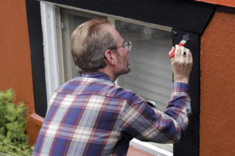 man painting window trim for spring refresh